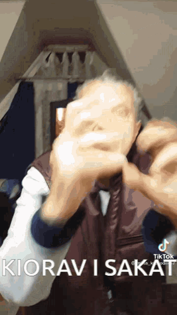 a man covering his face with his hands and the words kiorav i sakat in the corner