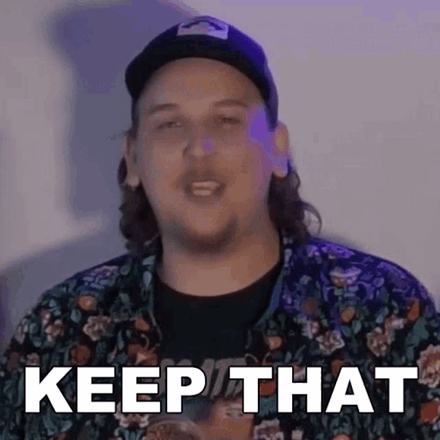 a man wearing a hat and a floral shirt says " keep that "
