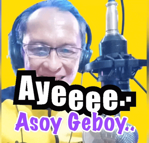 a man wearing headphones stands in front of a microphone with the words ayeeee-asoy geboy written above him