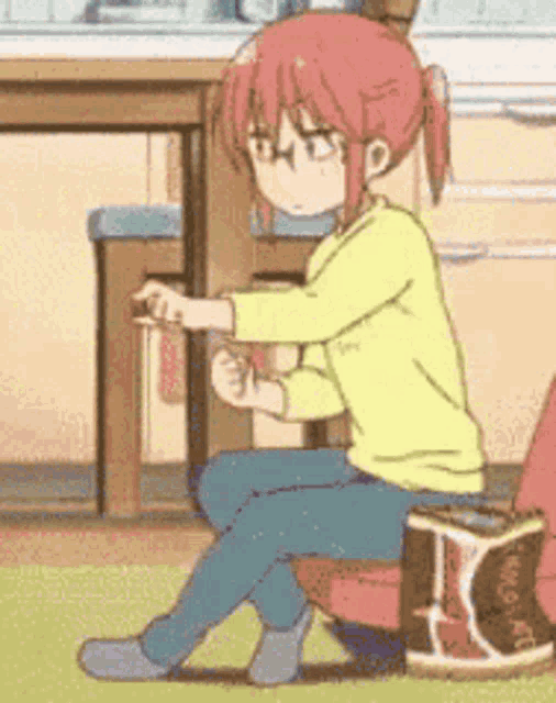 a girl with red hair and glasses is sitting on a chair in a kitchen .