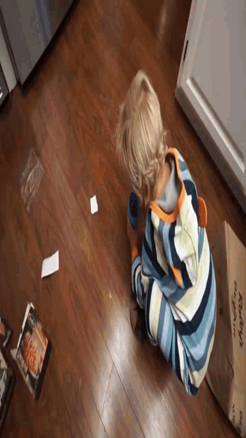 a young boy is playing with a box that says raley 's on it