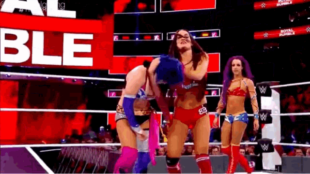 a group of women are wrestling in a ring with the word ble on the screen behind them .