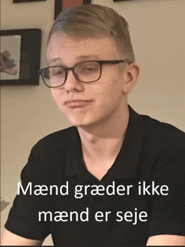 a young man wearing glasses and a black shirt with the words maend graeder ikke maend er seje written below him