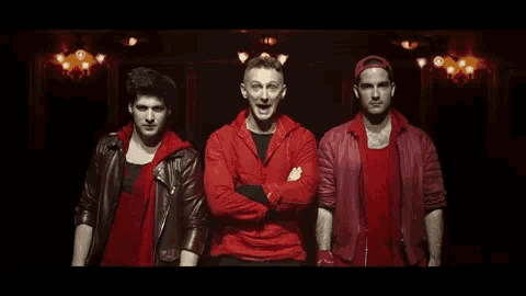 three men in red jackets and shirts are standing next to each other