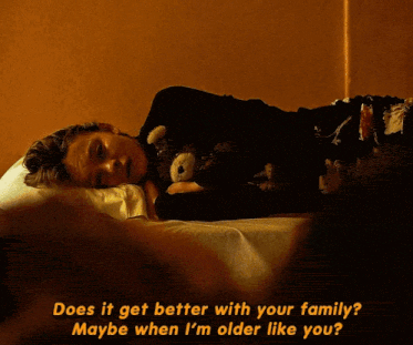 a person laying on a bed with the words " does it get better with your family " written above them