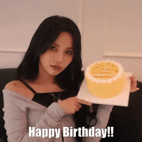 a woman is holding a cake with the words happy birthday written on the bottom