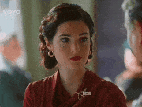 a woman in a red dress with a brooch that says " a " on it