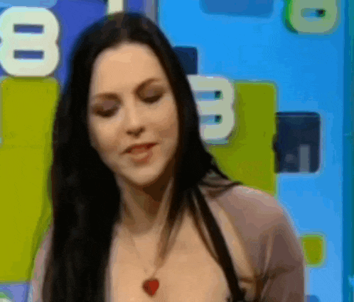 a woman is standing in front of a blue wall with a number 8 on it