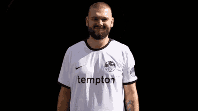 a man with a beard wears a white shirt with the word tempton on it