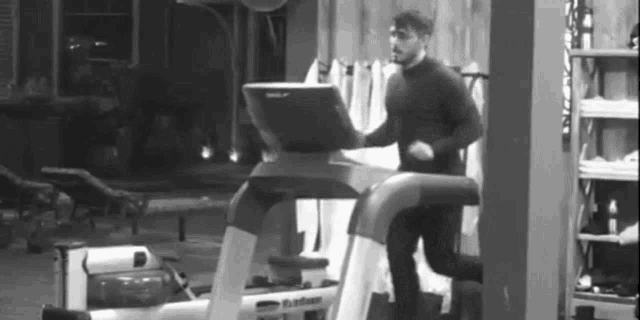a man is running on a treadmill in a black and white photo .