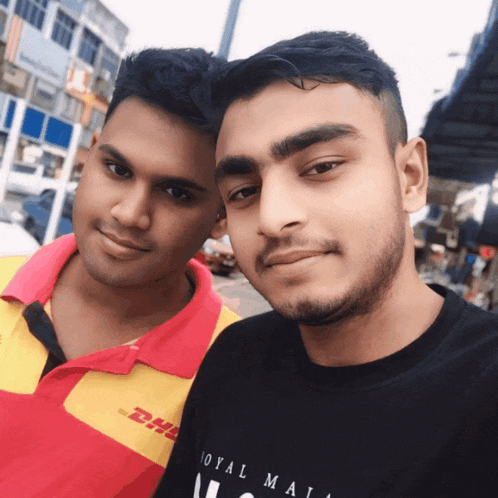two men are posing for a picture and one is wearing a dhl shirt