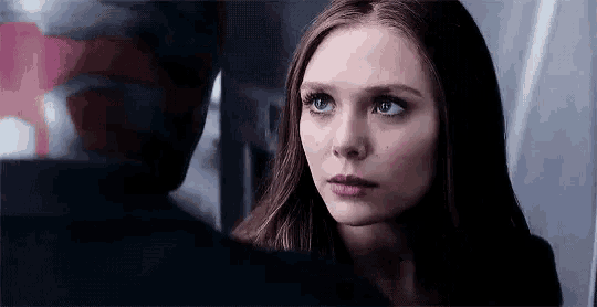 a close up of a woman looking at a man 's face in a mirror .