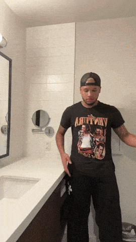 a man standing in a bathroom wearing a black t-shirt that says " ain't my "