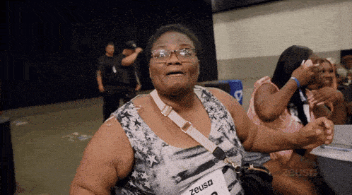 a woman with glasses and a name tag that says zeus