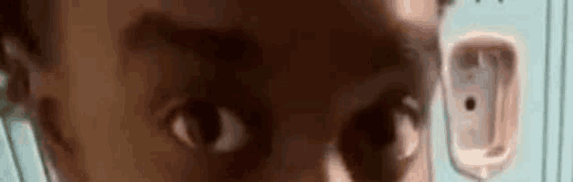 a close up of a person 's eyes in front of a urinal .