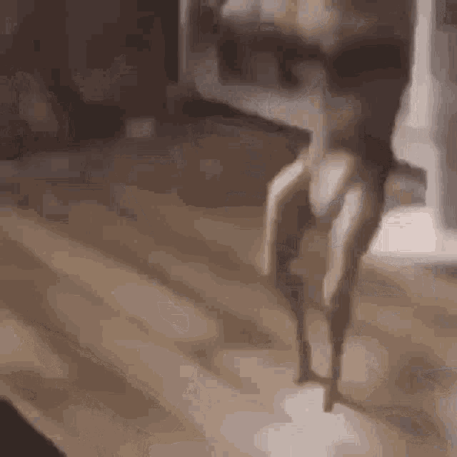 a person is standing on a wooden floor in a room with their legs crossed .