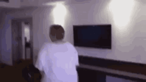 a person is standing in a living room with a television .