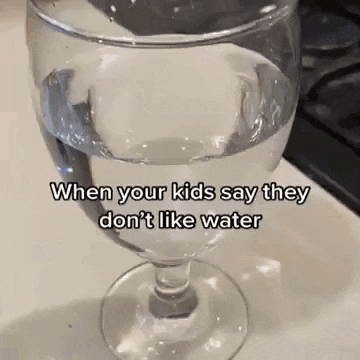 a glass of water is sitting on top of a counter .