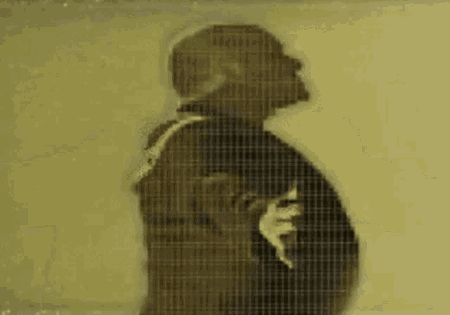 a silhouette of a man with his arms outstretched is behind a grid .