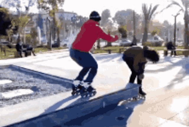 a man in a red hoodie is rollerblading on a railing