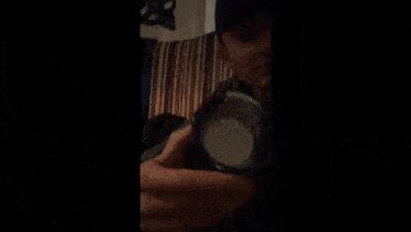 a man in a black hat is holding something in his hands