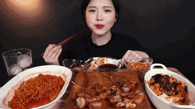a woman is sitting at a table eating a variety of food