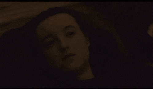 a close up of a woman 's face in a dark room