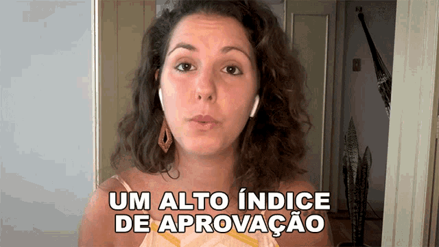 a woman says um alto indice de aprovacao while wearing headphones
