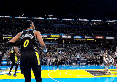 a basketball player wearing a number 0 jersey stands on the court