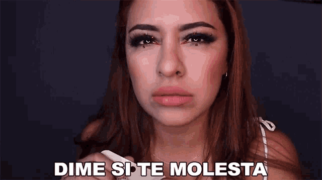 a woman is making a face and says dime si te molesta
