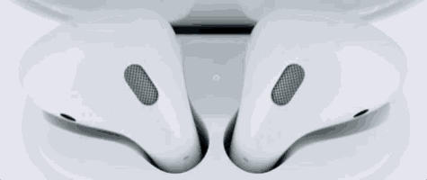 a pair of white ear buds with a green light on the bottom