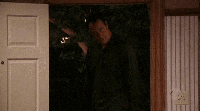 a man standing in a doorway with a cbs logo on the wall
