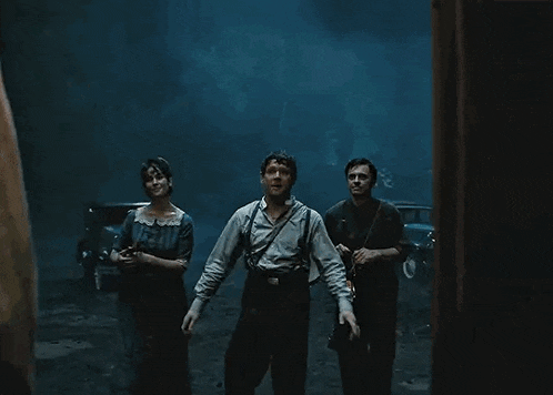 a group of people are standing in a dark room with a lantern .