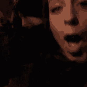 a close up of a person 's face with their mouth open in the dark .