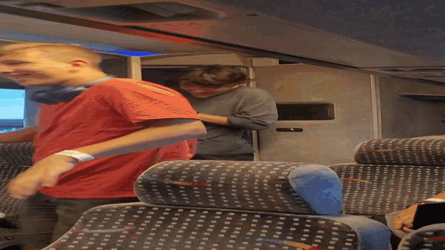 a man in a red shirt is laying on a train