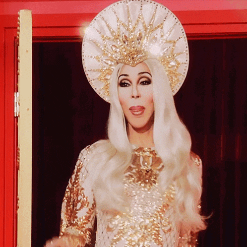 a woman wearing a white and gold costume and a crown
