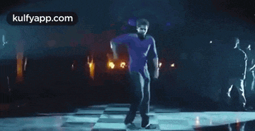 a man is dancing on a dance floor in a dark room with lights .
