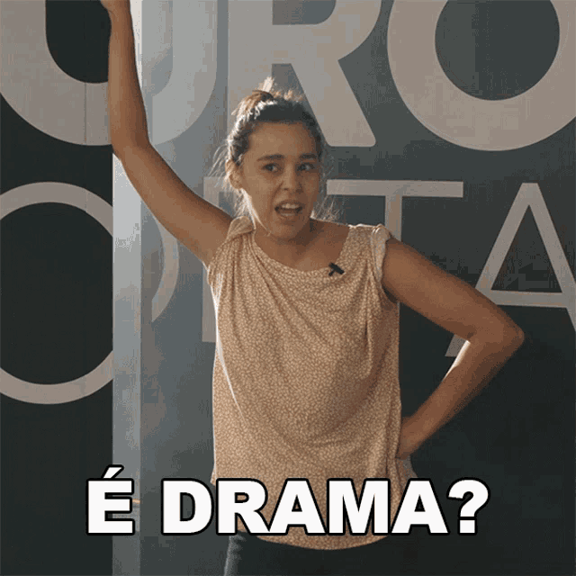 a woman stands in front of a wall that says ' e drama ' on it