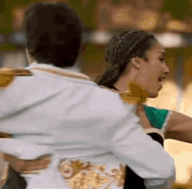 a man is carrying a woman in his arms while they dance .