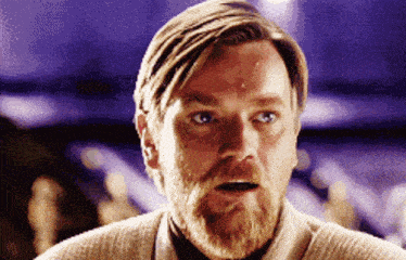 a man with a beard is looking at the camera with his mouth open