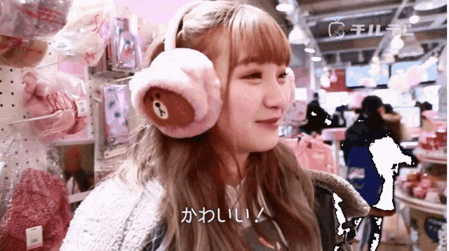 a girl wearing ear muffs with a bear on them