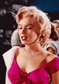marilyn monroe is wearing a pink dress and earrings