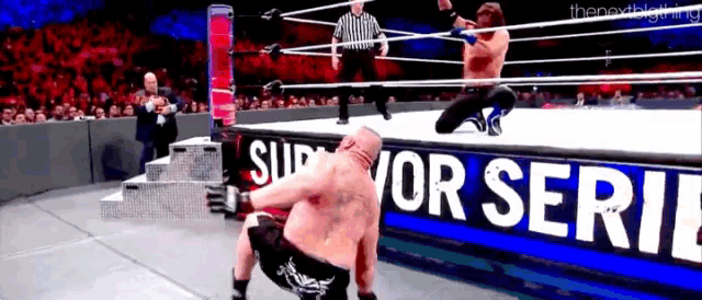 two men are wrestling in a ring with a sign that says survivor series on it .