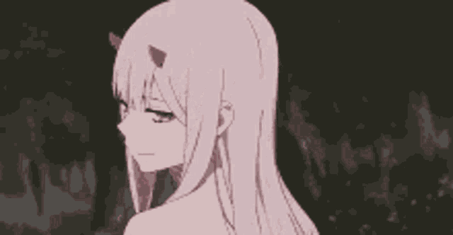 a pink haired anime girl with horns on her head is standing in a dark room .