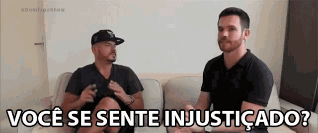 two men are sitting on a couch and one of them is saying " você se sente injusticado " .