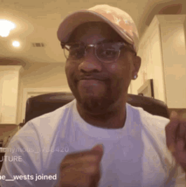 a man wearing glasses and a hat with the word wests joined on the bottom