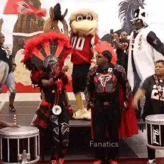 a group of people are standing in front of a mascot wearing a number 10 jersey .