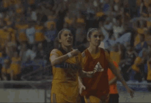a woman in a tigres jersey is celebrating
