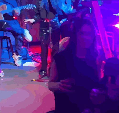 a man playing a guitar and a woman sitting in front of a microphone