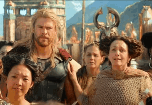 a group of people are standing around a man in a costume called thor